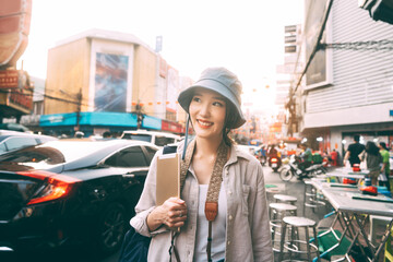 Walking  young adult asian woman traveller solo traveling with digital tablet at city on day.