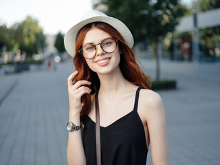 Fototapeta premium attractive woman walking on the street wearing hat and glasses