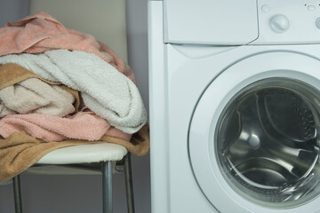 colorful laundry towels on the background of the washing machine