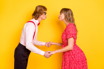 Photo portrait of cheerful lovely couple kissing on date valentines day isolated on vibrant yellow background