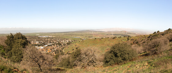 A panoramic  view from Mount Benthal of the nearby valley, settlements, fields, wind turbines and the snow-capped peak of Mount Hermon, in the Golan Heights, in northern Israel