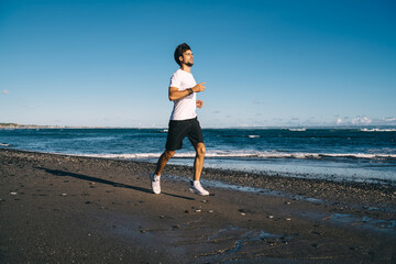 Young sportsman jogging on beach