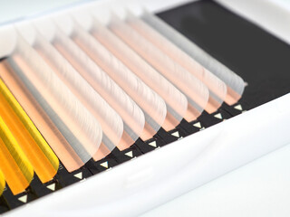Multi-colored artificial eyelashes for extension, two colors in the macro palette, yellow and white.