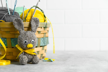 Easter crafting DIY. Handmade knitted toy Easter rabbit, and knitting accessories in the basket....