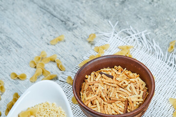 Two types of uncooked pasta on a gray background