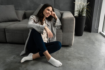 Obraz premium Beautiful young smiling woman sitting in a living room