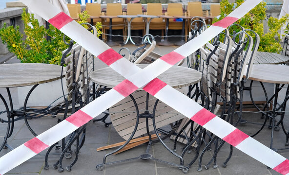 Gastronomy lockdown due to corona epidemic, closed restaurant terrace,chairs, tables and barrier tape, symbolic
