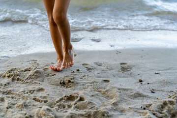 Closeup of a person's or child's feet walking on the beach, focus on arch of foot