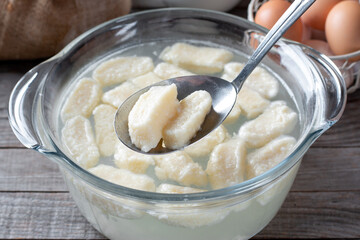 Gnocchi or cottage cheese dumplings being prepared. Adding into boiled water