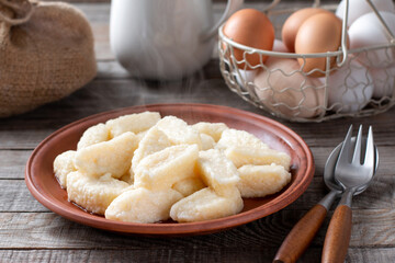 Lazy dumplings - vareniki of cottage cheese on a plate, on wooden background