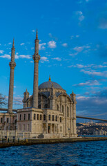 Vertical view of the Ortakoy Mosque on the Bosporus with 15th July Martyrs Bridge at sunset