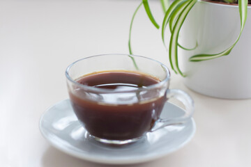 Fragrant black coffee stands on a light table. Breakfast with coffee. Make coffee in a turk.