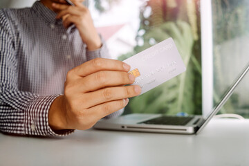 Business people use tablets and hold credit cards as an online shopping concept With a calculator and a book placed on the table