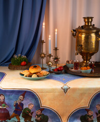 Beautiful Novruz table set up in blue with semeni, wheat grass, sweets and dry fruits and festive candles with tea and golden samovar.