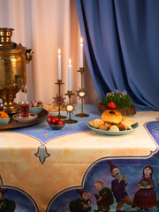 Beautiful Novruz table set up in blue with semeni, wheat grass, sweets and dry fruits and festive candles with tea and golden samovar.