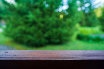 Fototapeta premium Nature background and wood table with free space for product display template, empty wooden free board over blur green tree at park, fresh garden with creamy bokeh, light and dark leaves background