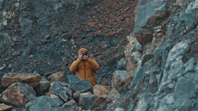 Traveler photographer takes photos on telephoto lens in mountains
