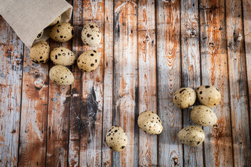 Top view on quail eggs  over  old wooden background, selective focus. Rustic style