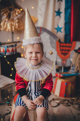 Fototapeta na wymiar White boy dressed as a magician. Stylized circus photo zone.