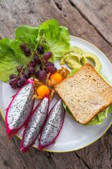Wheat bread and Chicken fillet with salad and Fresh fruit. Healthy food, diet lunch concept. Top view on wooden background.