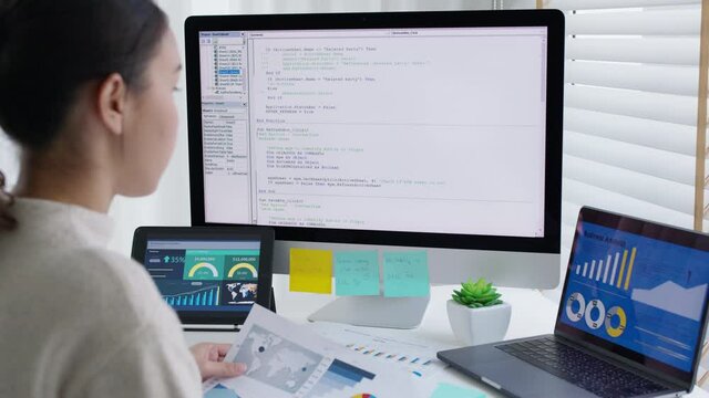 Back rear view of young asian woman, freelance data scientist work remotely at home coding programing on Big data mining, AI data engineering, IT Technician Works on Artificial Intelligence Project.