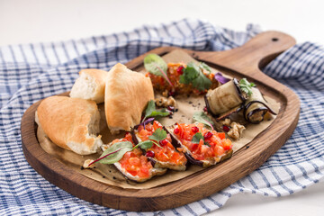 Baked eggplant appetizer with tomatoes, garlic and paprika and bread on wooden board