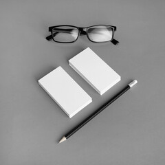 Blank branding identity set on gray paper background. Business cards, pencil and glasses. Corporate...