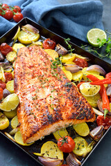 Großes saftiges Lachsfilet mit pikanter Chili-Honig-Marinade, mit Gemüse gebacken und heiß auf dem Backblech serviert - Juicy salmon fillet with a chili honey marinade baked with vegetables