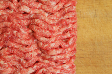 Fresh minced meat on the background of the kitchen board. Empty space for the text