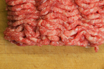 Fresh minced beef on the background of the kitchen board. Empty space for the text