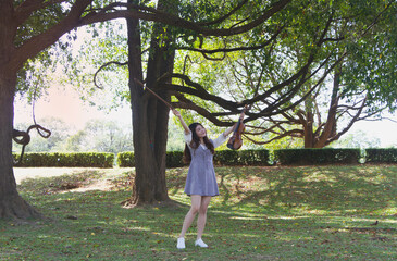 Young beautiful lady raise violin and bow up ,with happy feeling,portrait of model posing,in a park,