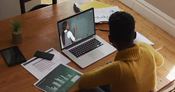 African american female student using computer on video call with female teacher