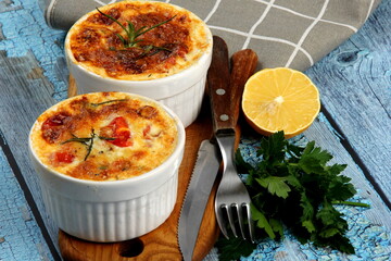 Cod casserole with cheese, sour cream and tomatoes. White fish casserole with cheese and sour cream, Baked fish on pot. Julienne of seafood