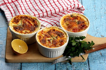 Cod casserole with cheese, sour cream and tomatoes. White fish casserole with cheese and sour cream, Baked fish on pot. Julienne of seafood