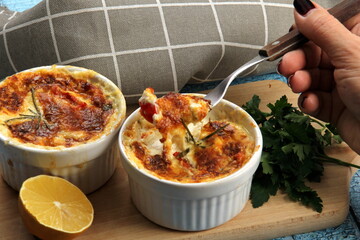 Cod casserole with cheese, sour cream and tomatoes. White fish casserole with cheese and sour cream, Baked fish on pot. Julienne of seafood