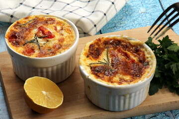 Cod casserole with cheese, sour cream and tomatoes. White fish casserole with cheese and sour cream, Baked fish on pot. Julienne of seafood