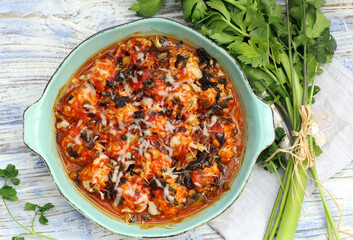bolas de arroz e carne picada, estufada em molho de tomate, coberta com queijo. 