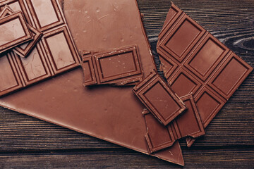 delicacy of sweet chocolate on wooden background top view texture