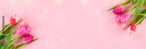 Banner with beautiful colorful tulips on light pink background with copy space and bokeh lights. Design for greeting card - Mother's Day, Women Day, 8 March or Valentines Day concept, selective focus