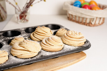 cruffins easter spring pastries, a mixture of muffin and croissant on a light background, the composition Easter painted eggs willow and cake