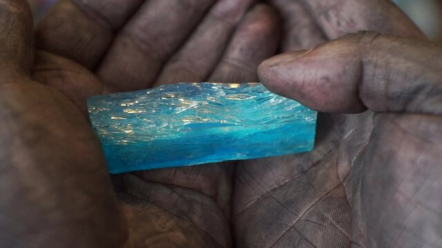 a large crystal lies in dirty male hands.close-up.shallow depth of field