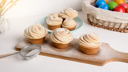 cruffins easter spring pastries, a mixture of muffin and croissant on a light background, the composition Easter painted eggs willow and cake