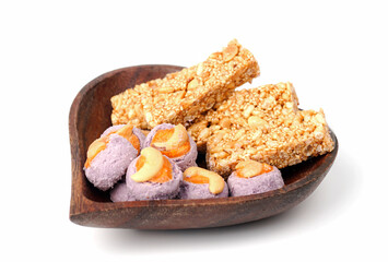 Traditional Thai dessert called Krayasart made from rice, nuts, sesame and sugar with taro cookies in a heart wooden bowl.
