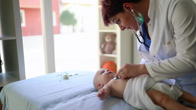 newborn baby get examine by pediatrician hold stethoscope, pediatric doctor monitoring heart pulse rate adorable infant  in clinic, pediatrician with child concept