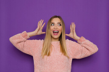 Happy Young Woman Is Holding Head In Hands, Looking At The Side And Shouting.