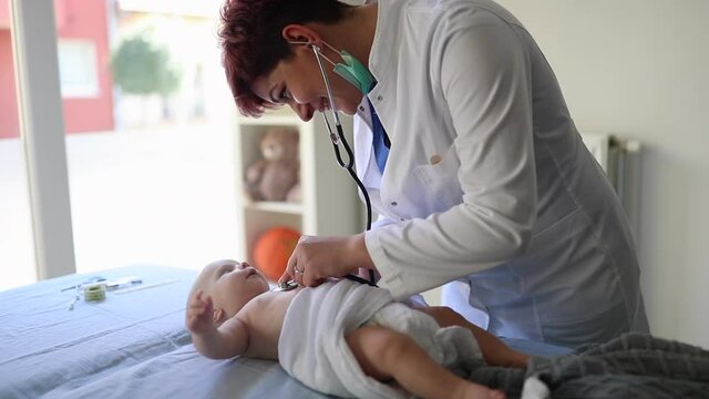 newborn baby get examine by pediatrician hold stethoscope, pediatric doctor monitoring heart pulse rate adorable infant  in clinic, pediatrician with child concept