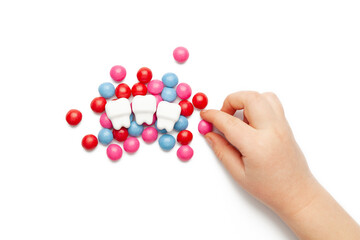 A child's hand reaches for sweets. The harm of sweets for the teeth.