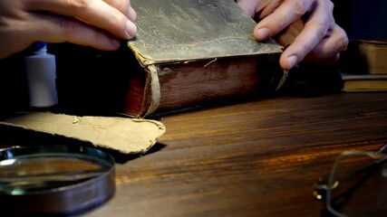 Close-up of hands gluing the cover to an old book.