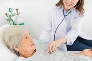 Obraz premium close up hand of doctor, asian female doctor use stethoscope listening and screening old asian patient, elderly health check up , palliative care, Unconscious patient