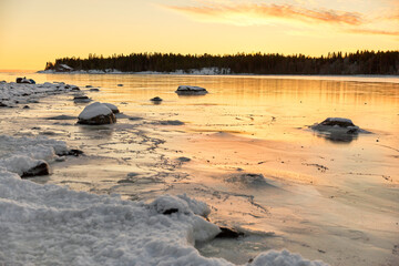 Frozen lake at sunset in winter